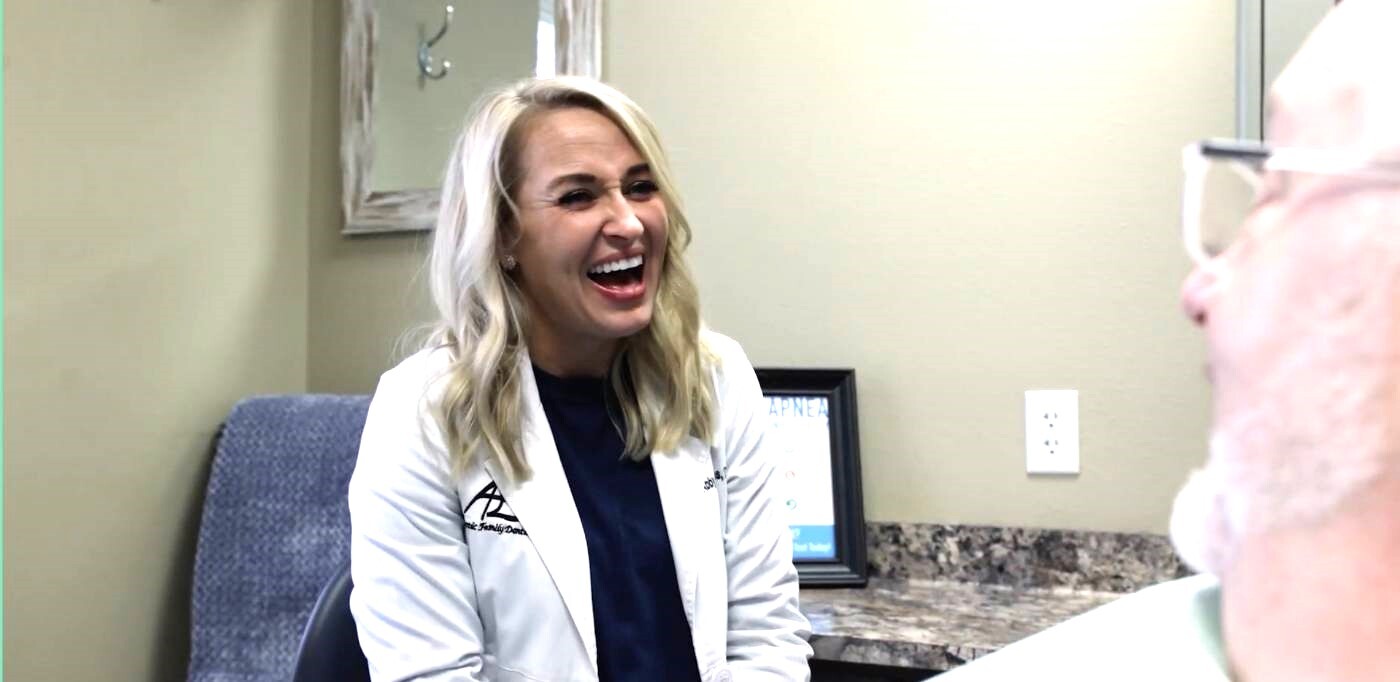 Doctor Williams laughing with a patient in the dental chair
