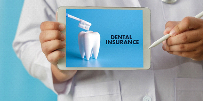 A dentist holding an ipad that says dental insurance