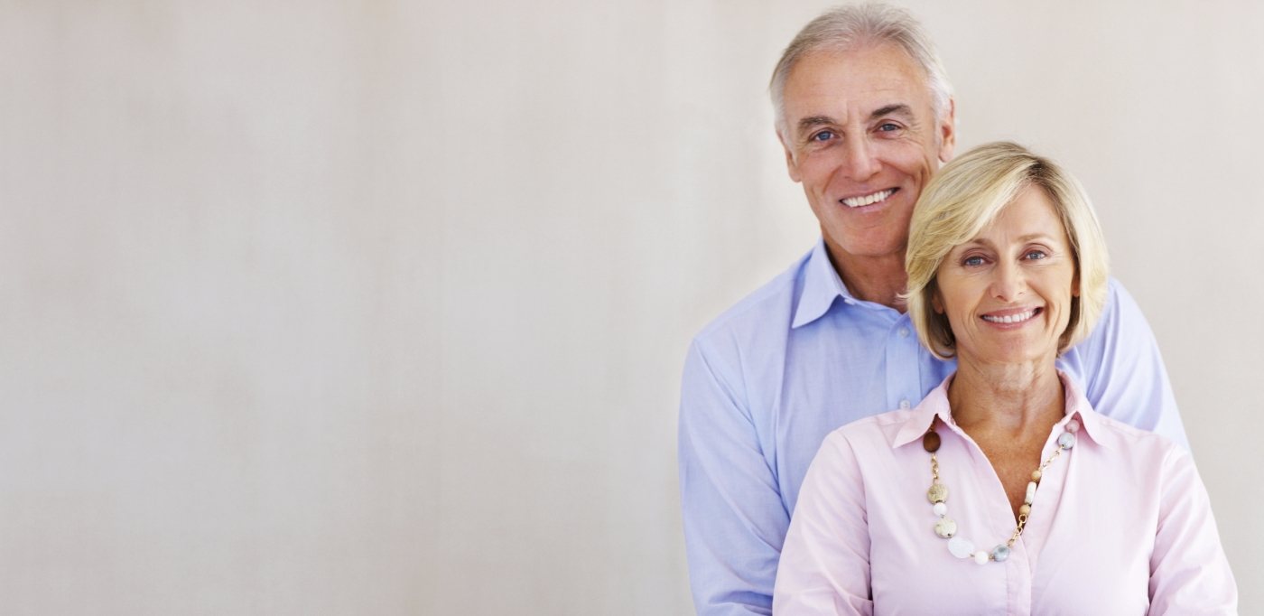 Older man and woman smiling together after receiving dental services in Baytown
