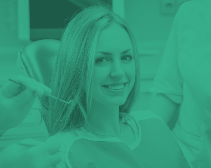 Smiling young woman sitting in dental chair during a dental checkup