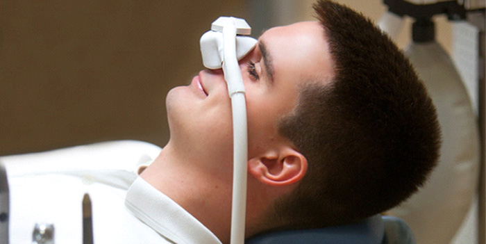 Patient relaxing while breathing in nitrous oxide in treatment chair